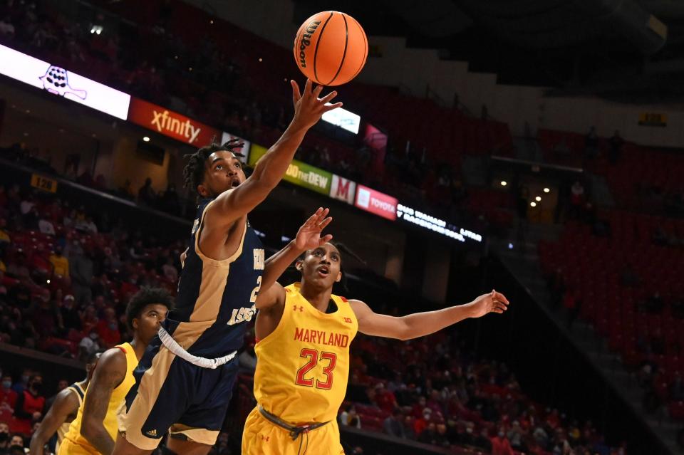 George Washington's Brayon Freeman, left, gets off a shot against Maryland's Ian Martinez during a game last November. Freeman is one of the new players on the URI roster.