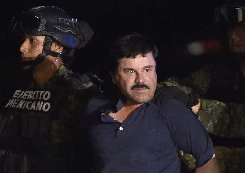 Drug kingpin Joaquin "El Chapo" Guzman is escorted to a helicopter at Mexico City's airport on January 8, 2016 following his recapture during an intense military operation in Los Mochis, in Sinaloa State. Mexican marines recaptured fugitive drug kingpin Joaquin "El Chapo" Guzman on Friday in the northwest of the country, six months after his spectacular prison break embarrassed authorities. AFP PHOTO / OMAR TORRES / AFP / OMAR TORRES (Photo credit should read OMAR TORRES/AFP via Getty Images)