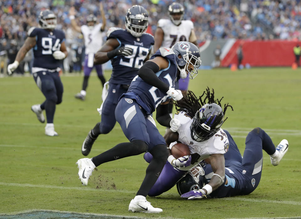 Baltimore Ravens running back Alex Collins (34) scores a touchdown as he is hit by Tennessee Titans cornerback Logan Ryan (26) in the first half of an NFL football game Sunday, Oct. 14, 2018, in Nashville, Tenn. (AP Photo/James Kenney)