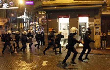 Riot policemen run after anti-government protesters near Taksim square in Istanbul March 12, 2014. REUTERS/Osman Orsal