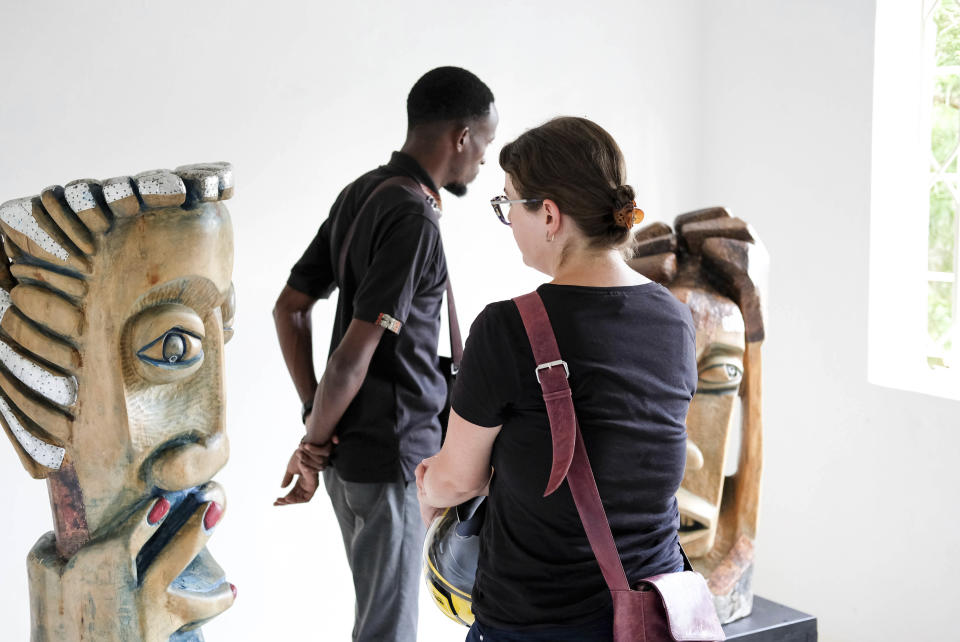 A lady looks at a sculpture piece during Lilian Nabulime's "Olugamba exhibition at Xenson Art Space in Kamwokya, Kampala, the capital of Uganda, on Tuesday Nov.28 2023. Lilian Nabulime hasn't forgotten the time in the 1990s when the Ugandan capital had just one commercial art gallery, a small space that emerging artists struggled to get into. Now there are at least six in Kampala, including one whose curators recently exhibited the sculptor's contrarian work. (AP Photo/Hajarah Nalwadda.)