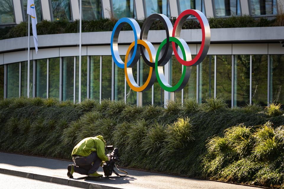 A cameraman films the Olympic Rings at the International Olympic Committee (IOC) headquarters in Lausanne on March 3, 2020. - The COVID-19 which has already killed more than 3000 people in the World will be at the center of a meeting of the International Olympic Committee (IOC) on March 3 and 4, 2020 in Lausanne less than five months before the opening ceremony of the Olympics in Tokyo. (Photo by Fabrice COFFRINI / AFP) (Photo by FABRICE COFFRINI/AFP via Getty Images)