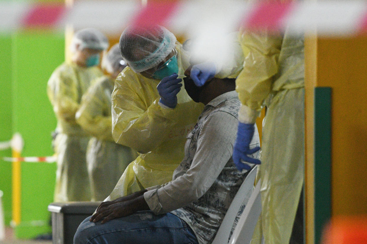 SINGAPORE, June 10, 2020  -- Healthcare staff collect swab samples for COVID-19 testing from workers who are returning for work at a regional screening centre in Singapore, June 10, 2020. (Photo by Then Chih Wey/Xinhua via Getty) (Xinhua/ via Getty Images)