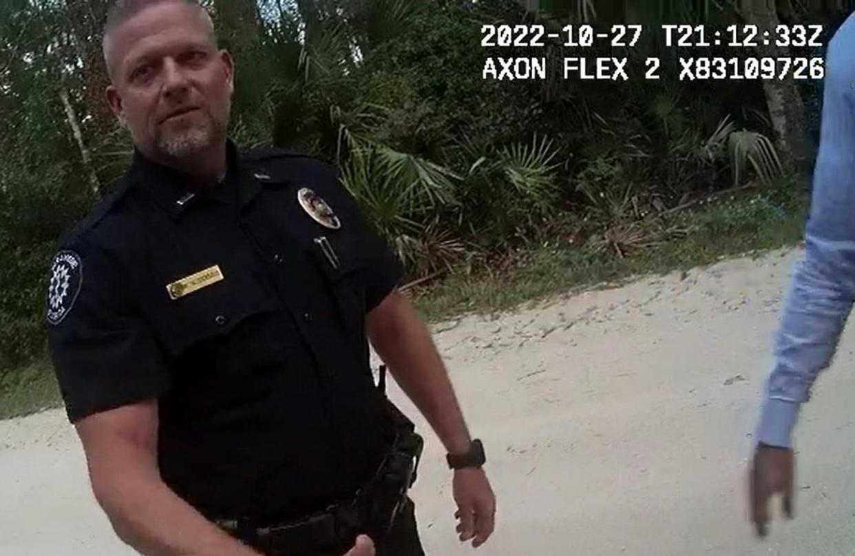 Daytona Beach Shores police Lt. Michael Schoenbrod meets two fellow law enforcement officers and a Florida Department of Children and Families caseworker on Oct. 27, 2022, outside his home. They were there to interview him about jailing his son earlier that month for a potty-training lesson.