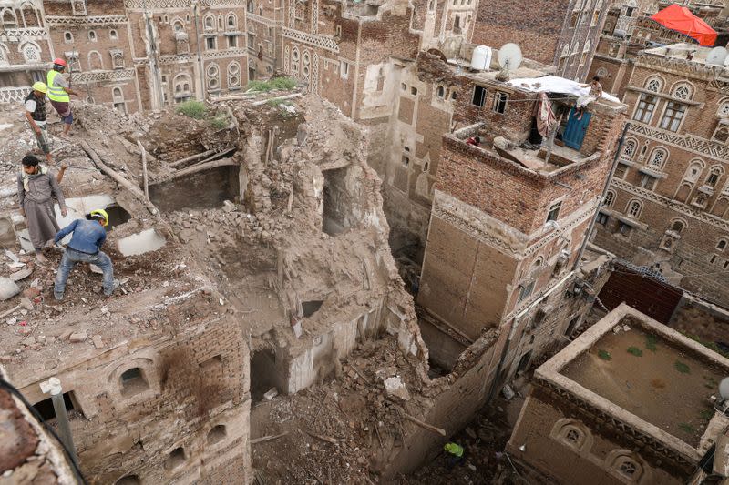 Workers demolish a building damaged by rain in the UNESCO World Heritage site of the old city of Sanaa