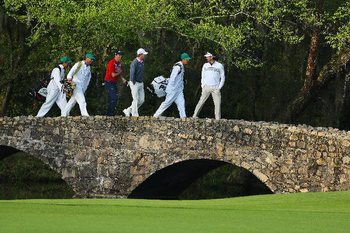 Golfers Webb Simpson, third from left, Brandt Snedeker, third from right, Bubba Watson, right, and their caddies cross the Byron Nelson Bridge after teeing off on the 13th hole during a practice round for the Masters golf tournament, Wednesday, April 9, 2014 in Augusta, Ga. (AP Photo/Atlanta Journal-Constitution, Curtis Compton) MARIETTA DAILY OUT; GWINNETT DAILY POST OUT; LOCAL TV OUT; WXIA-TV OUT; WGCL-TV OUT