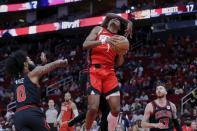 Houston Rockets forward Amen Thompson (1) is fouled by Chicago Bulls forward Torrey Craig, behind, as he attempts a layup between Bulls guard Coby White (0) and forward Onuralp Bitim (17) during the first half of an NBA basketball game Thursday, March 21, 2024, in Houston. (AP Photo/Michael Wyke)