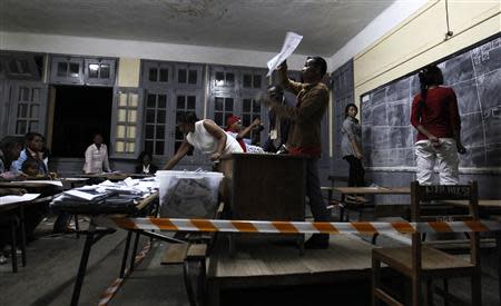 An official from Madagascar's Commission Electorale Nationale Independante pour la Transition (CENI-T) displays a ballot to agents as he counts votes at a polling centre in Madagascar's capital Antananarivo, December 20, 2013. REUTERS/Thomas Mukoya