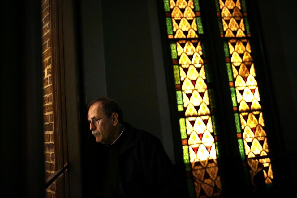 In this Jan. 15, 2013 photo, Jeff Jerome looks out of a window in Westminster Hall, which overlooks the cemetery that is home to Edgar Allan Poe's grave, in Baltimore. For years, Jerome watched as a mysterious man known as the Poe Toaster left three roses and an unfinished bottle of cognac at Poe’s grave every year on the legendary writer’s birthday. His identity is a great modern mystery, and just as mysteriously, the tradition ended four years ago. (AP Photo/Patrick Semansky)