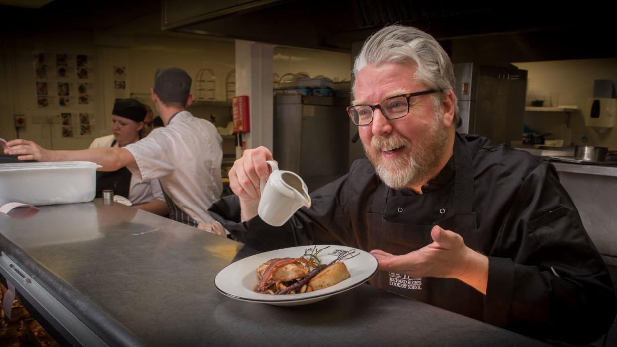 Chef Richard Hughes serving a meal