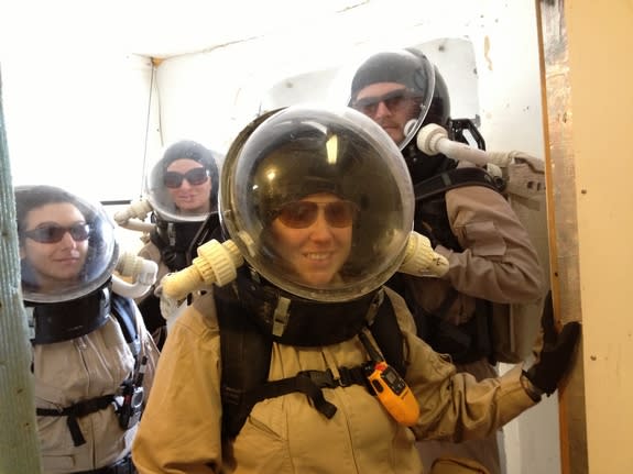 A previous Mars Desert Research Station crew wearing spacesuits to take part in a simulated spacewalk outside the habitat. Front: April Davis. Back, left to right: Audrey Bruneau, Åse Svendsen, Dennis Oltheten.