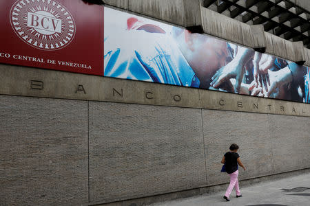 FILE PHOTO: A woman walks outside of the Venezuela's Central Bank in Caracas, Venezuela, January 31, 2018. REUTERS/Marco Bello/File Photo