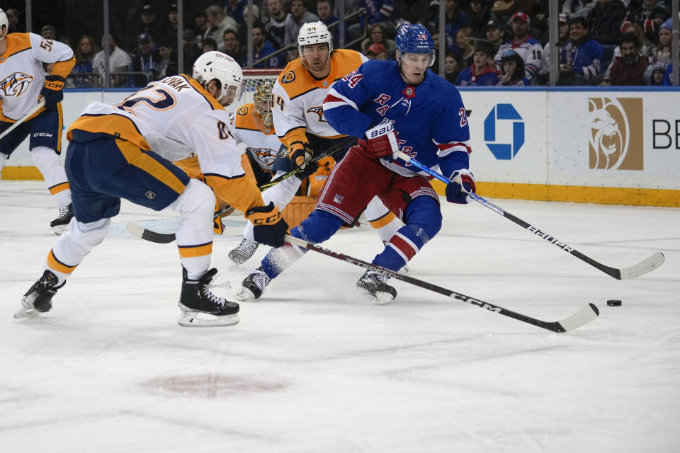 New York Rangers right wing Kaapo Kakko (24) skates with the puck against Nashville Predators center Tommy Novak (82) during the first period of an NHL hockey game Sunday, March 19, 2023, in New York. (AP Photo/Bryan Woolston)