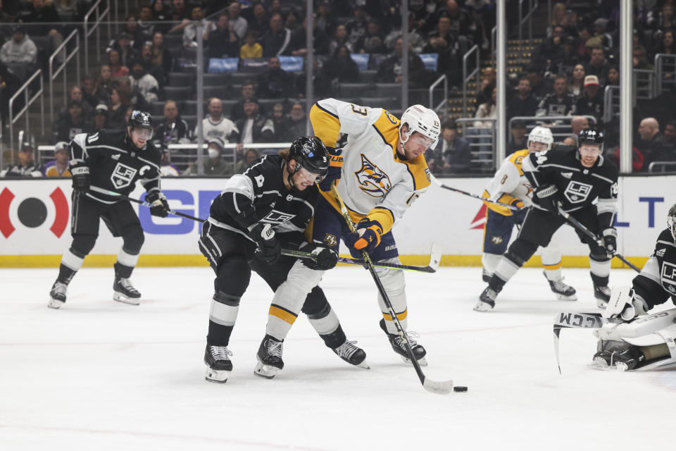 Nashville Predators center Yakov Trenin (13) attempts to score a goal as Los Angeles Kings right wing Adrian Kempe (9) defends during the first period of an NHL hockey game Thursday, Feb. 22, 2024, in Los Angeles. (AP Photo/Yannick Peterhans)