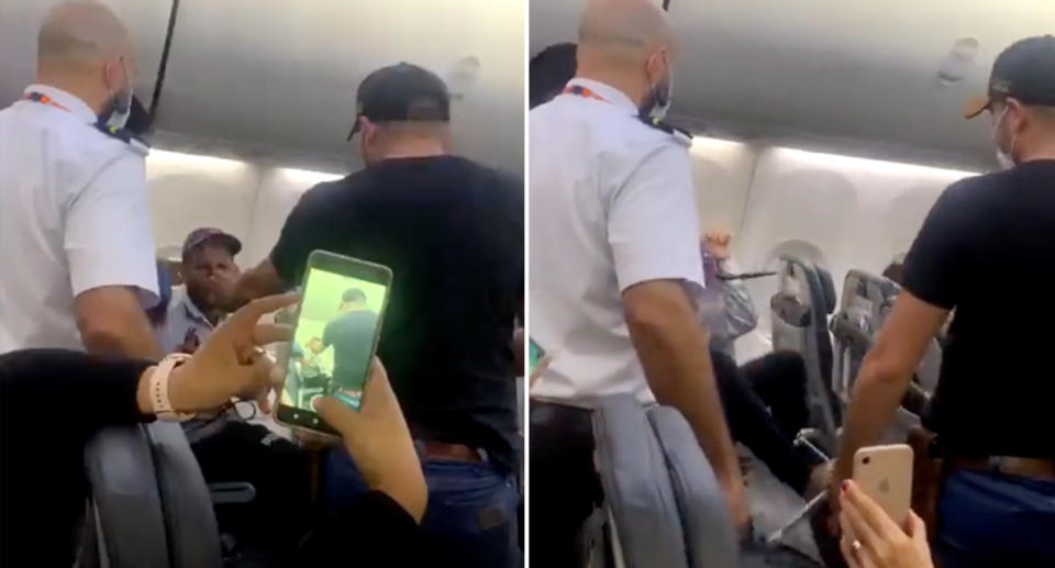 The passenger breaking his folding table as others on the flight try to calm him down.