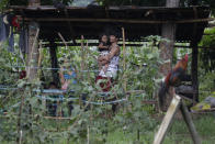 Ronnel Manjares, right, carries his daughter Crystal outside their house in Tanauan, Batangas province, Philippines, Wednesday, July 15, 2020. His 16-day-old son Kobe Christ Manjares was heralded as the country's youngest COVID-19 survivor. But the relief and joy proved didn't last. Three days later, Kobe died on June 4 from complications of Hirschsprung disease, a rare birth defect. (AP Photo/Aaron Favila)