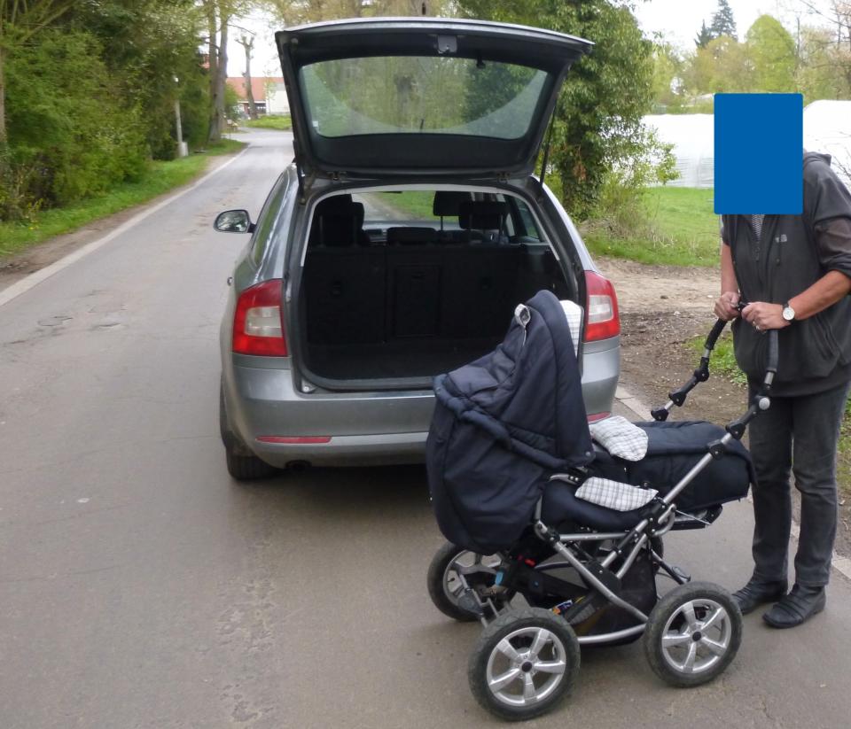 Großeltern ziehen Kinderwagen mit Auto