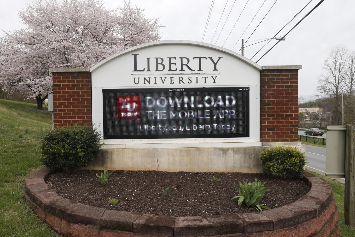 This file photo shows a sign that marks an entrance to Liberty University as students were welcomed back to the campus during the coronavirus outbreak in Lynchburg, Va. A former spokesman for Liberty University is suing the evangelical Virginia school after being fired, alleging in a lawsuit filed Monday, Oct. 25, 2021, that his termination came in retaliation for voicing concerns that sexual misconduct accusations were mishandled.