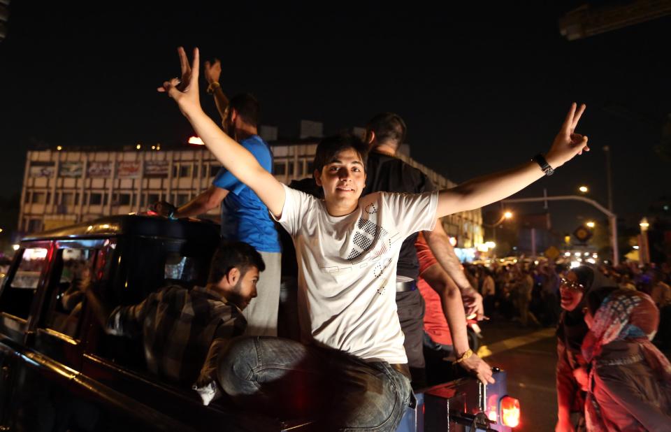 Iranians gather as they celebrate the victory of moderate presidential candidate Hassan Rouhaniin the presidential elections at Vanak Square, in northern Tehran, on June 15, 2013. Iranian Interior Minister Mohammad Mostafa Najjar said Rouhani won outright with 18.6 million votes, or 50.68 percent. (ATTA KENARE/AFP/Getty Images)