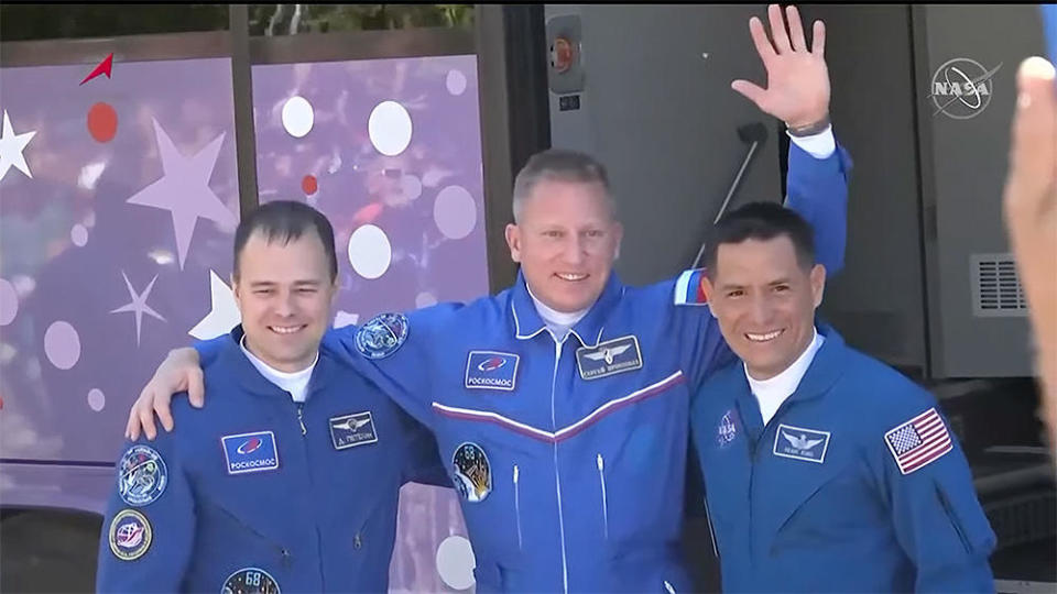 Soyuz flight engineer Dmitry Petelin, left, commander Sergey Prokopyev, center, and NASA astronaut Frank Rubio wave farewell to family, friends and supporters before suiting up and heading to the launch for blastoff on a flight to the International Space Station. / Credit: NASA TV