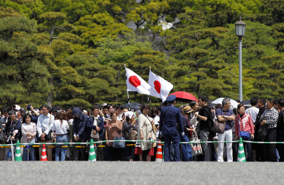 People gather around the Imperial Palace where Crown Prince Naruhito is to be enthroned to become new Japanese Emperor Wednesday, May 1, 2019, in Tokyo. Japan has new Emperor Naruhito to perform his first ritual after succeeding the Chrysanthemum Throne from his father Akihito who abdicated the night before. (AP Photo/Eugene Hoshiko)