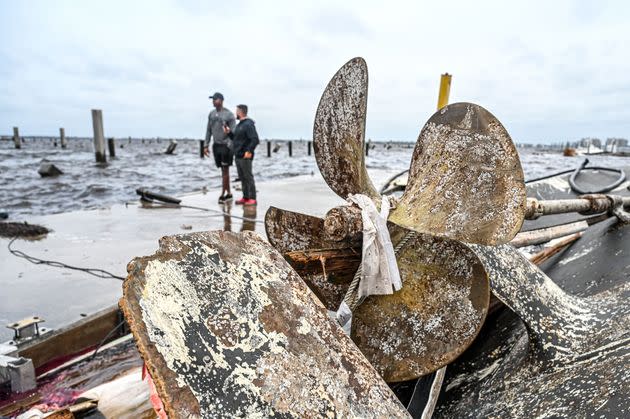 Residents inspect damage to a marina as boats are partially submerged in the aftermath of Hurricane Ian in Fort Myers, on Sept. 29. (Photo: GIORGIO VIERA via Getty Images)