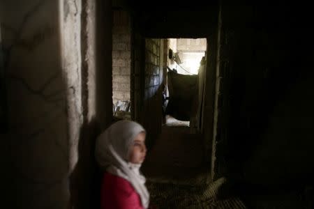 Internally displaced children stand inside a building they are currently living in, inside the rebel-held besieged eastern Ghouta of Damascus, Syria. REUTERS/Bassam Khabieh