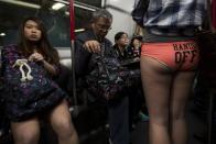 A woman takes part in the annual "No Pants Subway Ride" on a Mass Transit Railway (MTR) train in Hong Kong January 12,2014. The event involves participants who strip down to their underwear as they go about their normal routine. REUTERS/Tyrone Siu (CHINA - Tags: SOCIETY)