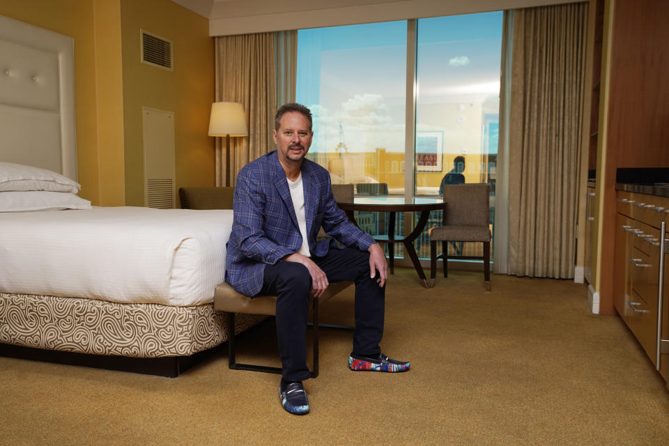 Lane Blue sits for a portrait in a condo he bought in the Trump International Hotel Las Vegas, Saturday, May 22, 2021, in Las Vegas. "They're giving them away," says Blue who paid $160,500 in March for a studio in Trump's Las Vegas tower, $350,000 less than the seller had paid in 2008. It was his second purchase in the building this year and may not be his last. "I'm thinking of picking up another one." (AP Photo/John Locher)