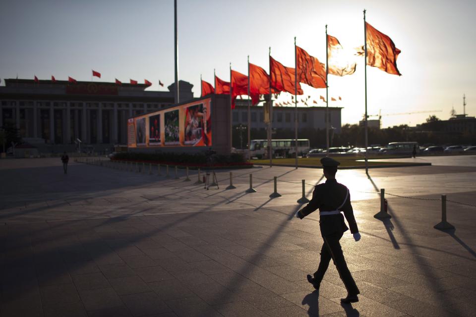 A paramilitary policeman patrols on Tiananmen Square, where Communist Party propaganda video images are shown on electronic boards, before the closing ceremony for the 18th Communist Party Congress, held at the nearby Great Hall of the People, in Beijing Wednesday, Nov. 14, 2012. President Hu Jintao stepped aside as Communist Party leader to clear the way for Vice President Xi Jinping to take the helm in China. (AP Photo/Alexander F. Yuan)