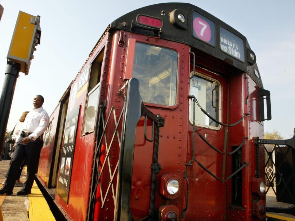 A man exits the last "Redbird" subway train on an outdoor platform