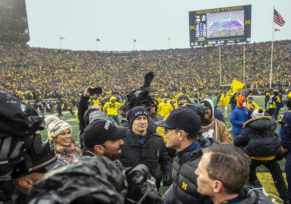 Ohio State head coach Ryan Day, center left, shakes hands with Michigan head coach Jim Harbaugh, center right, after an NCAA college football game in Ann Arbor, Mich., Saturday, Nov. 27, 2021. Michigan won 42-27. (AP Photo/Tony Ding)