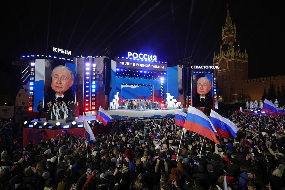 Russian President Vladimir Putin is seen on the screens as he attends a concert marking his victory in a presidential election and the 10-year anniversary of Crimea's annexation by Russia on Red Square in Moscow, Russia, Monday, March 18, 2024. President Vladimir Putin seized Crimea from Ukraine a decade ago, a move that sent his popularity soaring but was widely denounced as illegal. (AP Photo/Alexander Zemlianichenko)