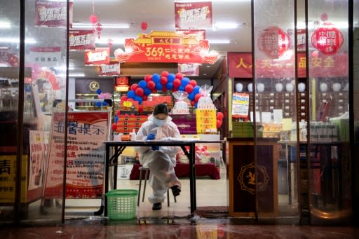 A vendor wears protective gear in Yueyang, Hunan province, China, where massive quarantine efforts have paid off