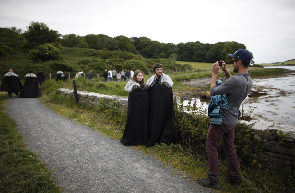 En esta foto del 13 de junio del 2014, fans de "Game of Thrones" se toman fotos en camino al prado y castillo de Audley, en Strangford, en el norte de Irlanda. El lugar sirvió de escenario para la primera temporada de la serie de HBO, cuando el rey Robert Baratheon y su séquito llegaron a Winterfell. (AP Foto/Peter Morrison, Archivo)