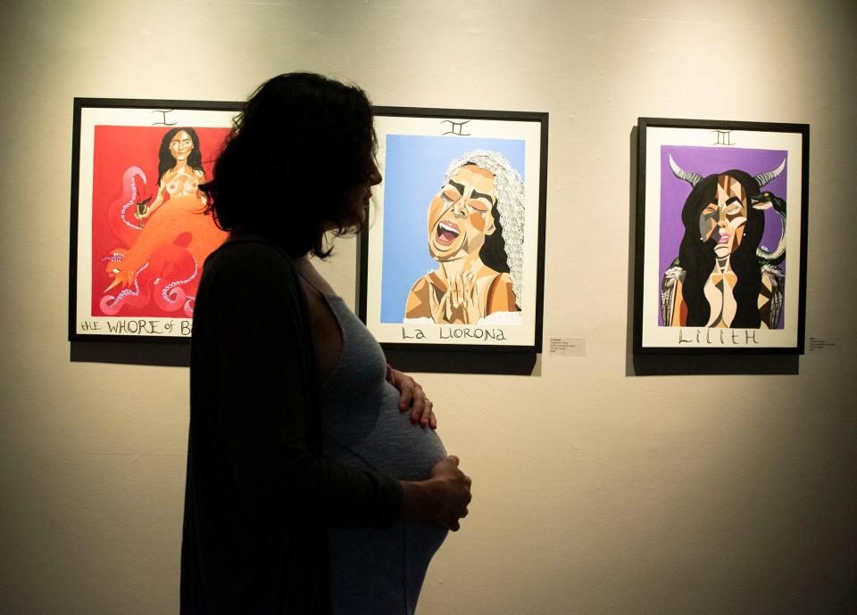 Cassandra with her artwork at an exhibition she curated themed around reproductive trauma at Durham Arts Council in Durham, N.C., on May 26, 2022. 