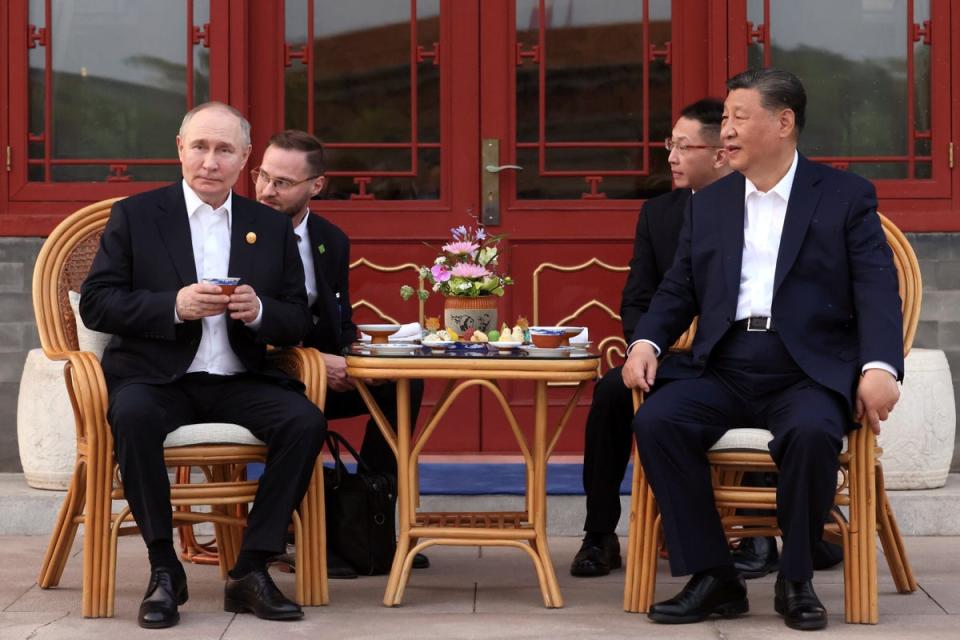 Vladimir Putin and Xi Jinping attend an informal meeting in Beijing (AP)