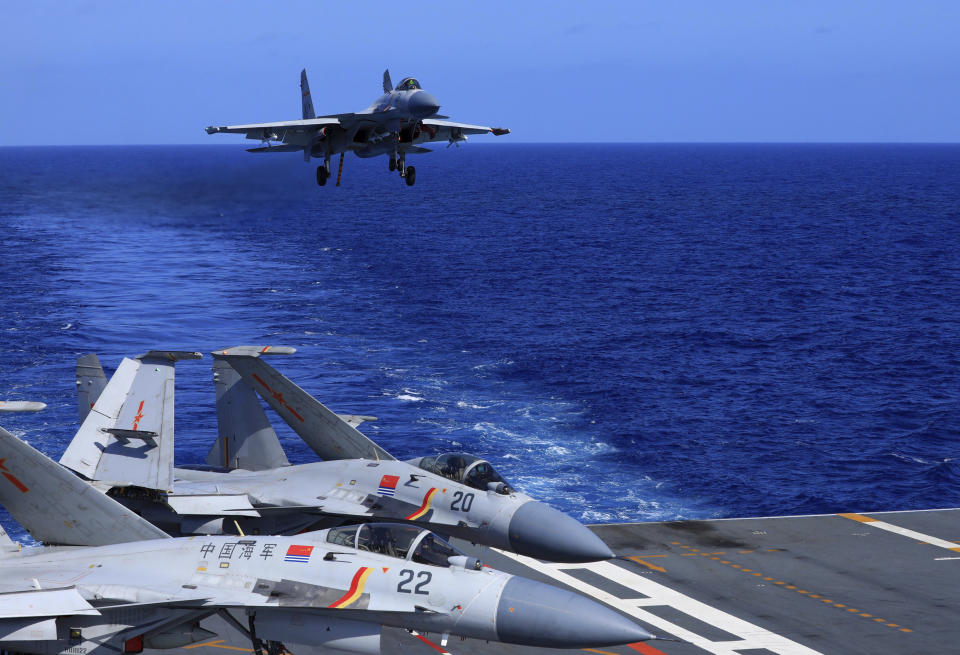 In this photo released Dec. 31, 2021, by Xinhua News Agency, an undated photo shows a carrier-based J-15 fighter jet preparing to land on the Chinese navy's Liaoning aircraft-carrier during open-sea combat training. China is holding military exercises in the disputed South China Sea coinciding with U.S. President Joe Biden's visits to South Korea and Japan that are largely focused on countering the perceived threat from China. (Hu Shanmin/Xinhua via AP)