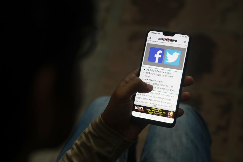 FILE – In this Dec. 20, 2018, file photo, a Bangladeshi reads a news report that makes mention of Facebook along with other social networking service, on his mobile phone in Dhaka, Bangladesh. Internal company documents from the former Facebook product manager-turned-whistleblower Frances Haugen show that in some of the world's most volatile regions, terrorist content and hate speech proliferate because the company remains short on moderators who speak local languages and understand cultural contexts. (AP Photo, File)