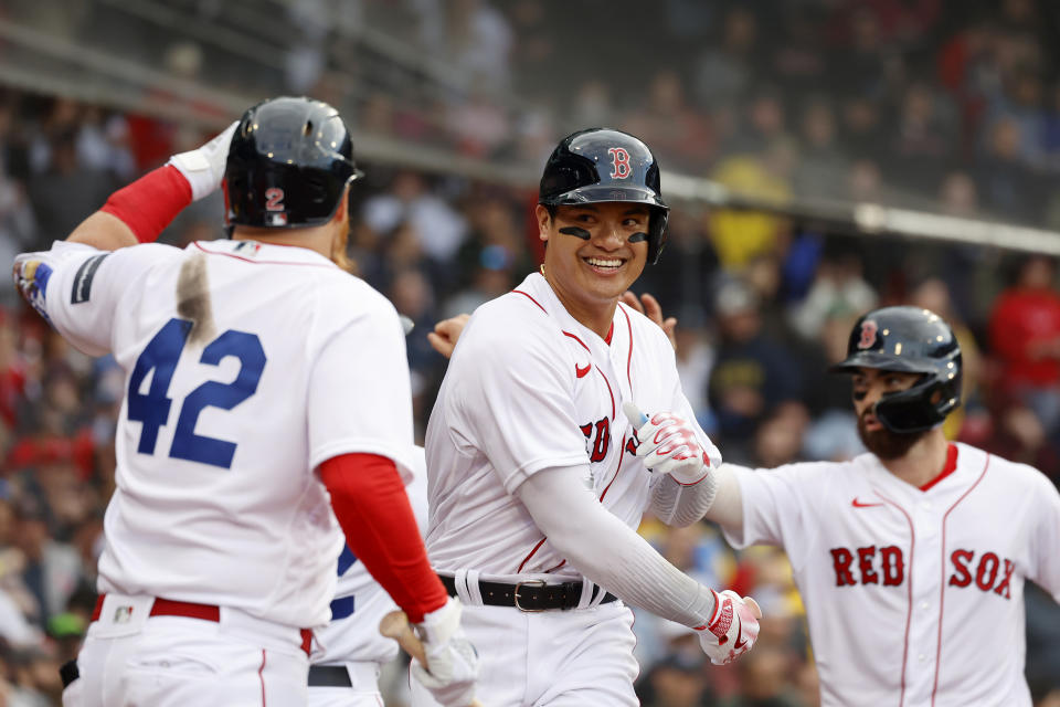 Boston Red Sox's Yu Chang, center, is congratulated by teammates after hitting a two-run home run during the fourth inning of a baseball game against the Los Angeles Angels at Fenway Park, Saturday, April 15, 2023, in Boston. (AP Photo/Mary Schwalm)