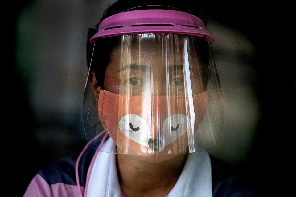 THAILAND: A volunteer at a COVID-19 screening center in Bangkok wears a face mask and a face shield.