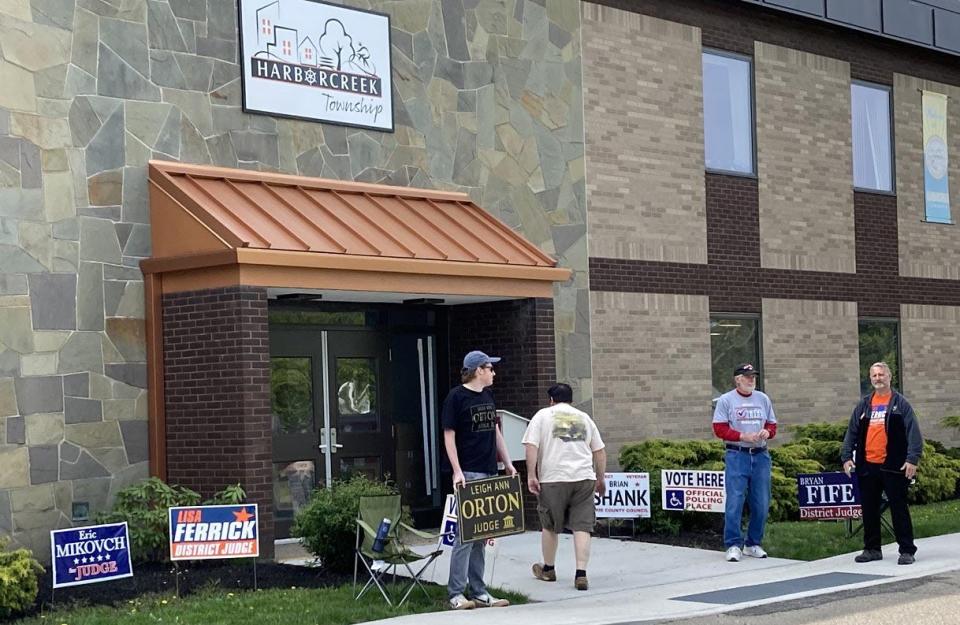 A voter walks into the Harborcreek Township Municipal Building on Tuesday morning as representatives of several candidates stand outside the building. Turnout was light at several Erie-area polling places for the 2023 primary.