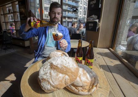 Sebastien Morvan, one of the founders of microbrewery Brussels Beer Project, displays bread and serves a beer called Babylone at Barbeton bar in central Brussels, April 14, 2015. REUTERS/Yves Herman