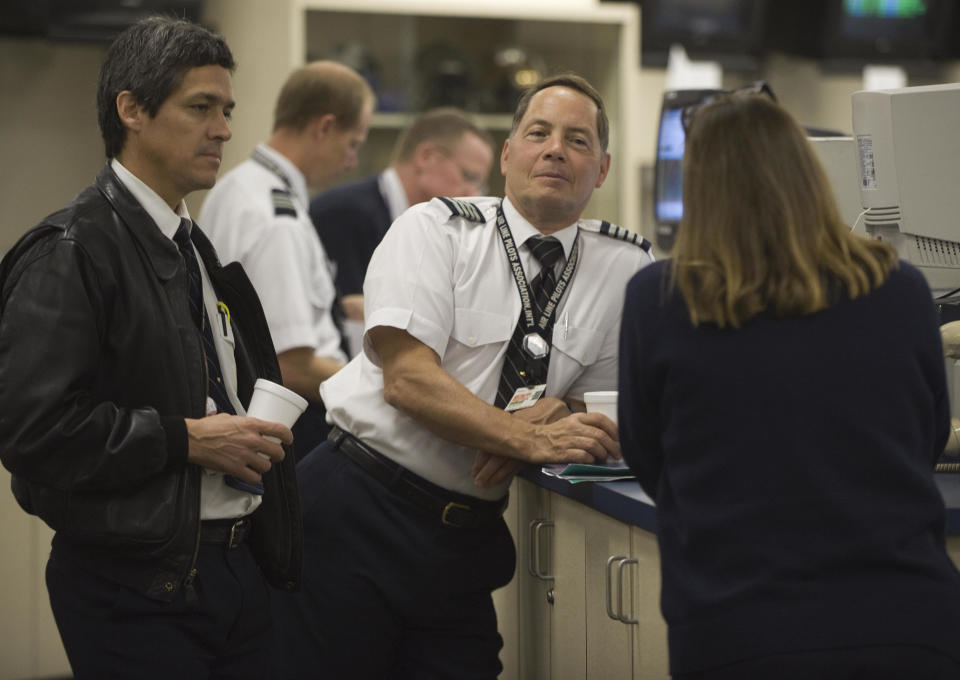 FedEx pilots relax and have a coffee as packages and documents are being loaded onto their aircraft while waiting for their flight assignments at the Memphis, Tennessee, Headquarters World Hub, where the bulk of FedEx's 675 world wide fleet of aircraft are being readied for take off, October 9, 2008.   The FedEx Memphis hub is a giant operation with over 10,000 daily employees on a 727- acre facilty that processes the majority of FedEx documents moving in, out, or thru the US and then on to the destination city within a few hours.      AFP PHOTO/Paul J. Richards (Photo credit should read PAUL J. RICHARDS/AFP via Getty Images)