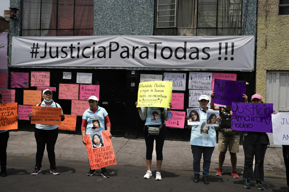 Friends and family holds images of women who have gone missing, during a protest outside an apartment rented by a suspected serial killer, in the Iztacalco neighborhood of Mexico City, Friday, April 26, 2024. Protesters covered the facade of the building with placards after investigators found the bones, cell phones and ID cards of several women at rented rooms there. (AP Photo/Marco Ugarte)