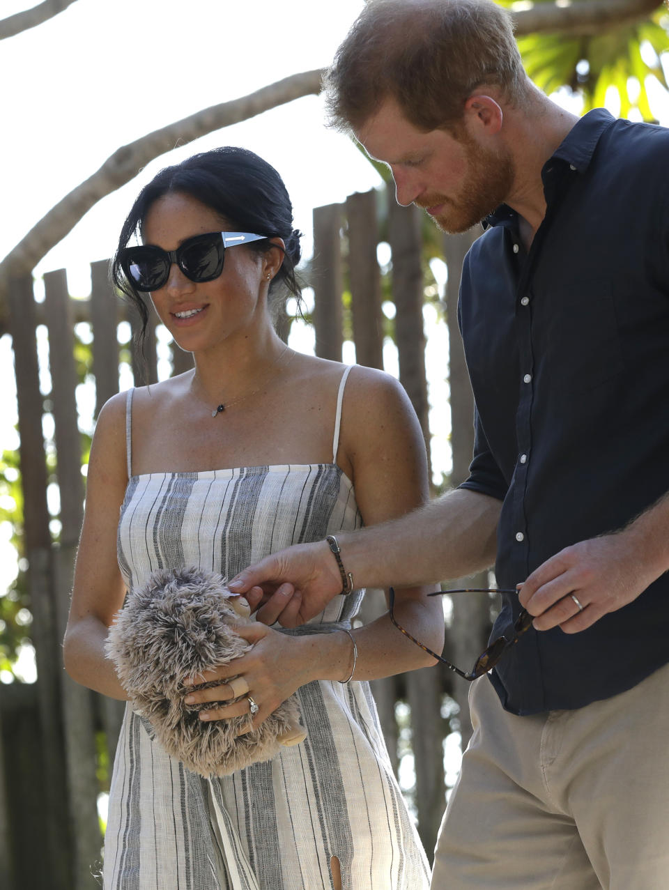 Meghan, Duchess of Sussex holds a gift from a member of the public as she walks along Kingfisher Bay Jetty with Britain's Prince Harry during a visit to Fraser Island, Australia, Monday, Oct. 22, 2018. Prince Harry and his wife Meghan are on day seven of their 16-day tour of Australia and the South Pacific. (AP Photo/Kirsty Wigglesworth, Pool)