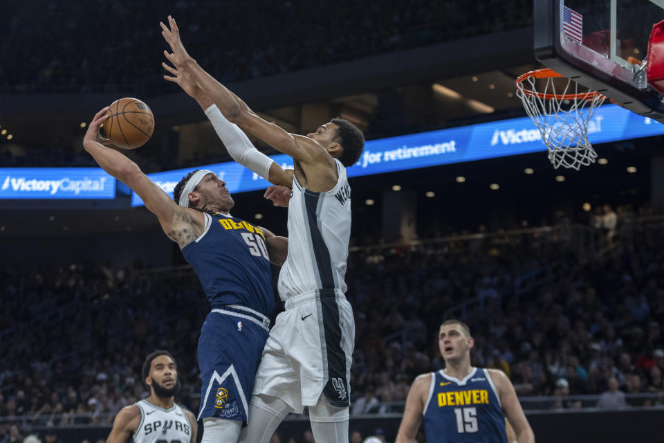 Denver Nuggets forward Aaron Gordon (50) looks to score past San Antonio Spurs center Victor Wembanyama, center right, during the first half of an NBA basketball game, Friday, March 15, 2024, in Austin, Texas. (AP Photo/Stephen Spillman)