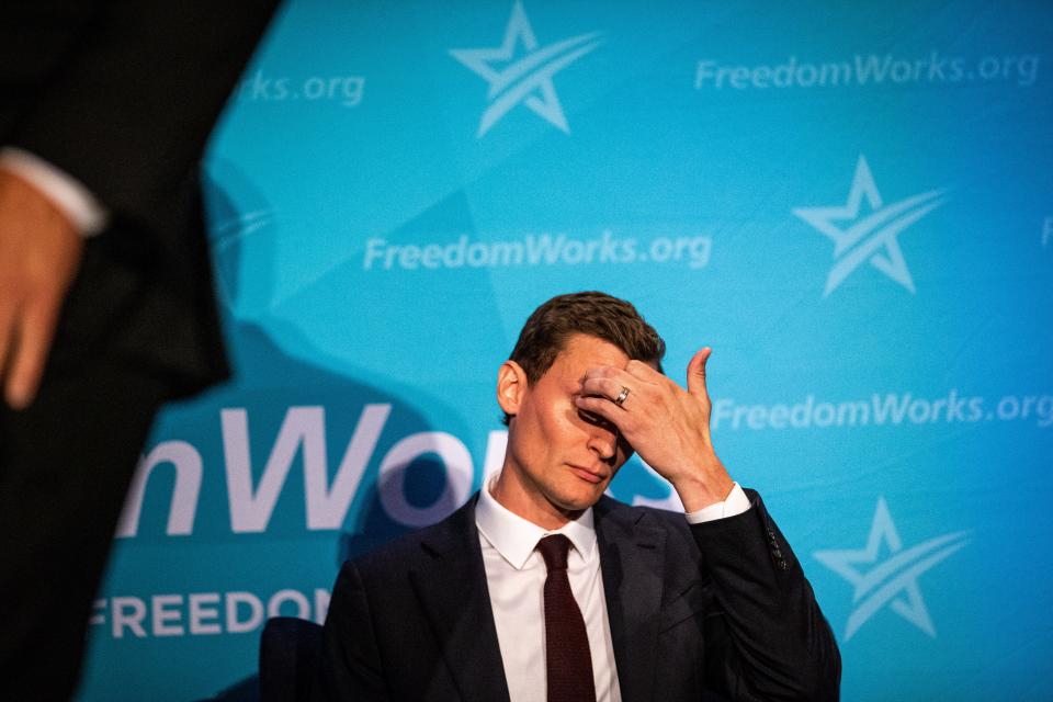 Blake Masters scratches his forehead while an opponent speaks to a crowd of Republican voters at the party's primary debate for the U.S Senate in Phoenix on June 23, 2022.