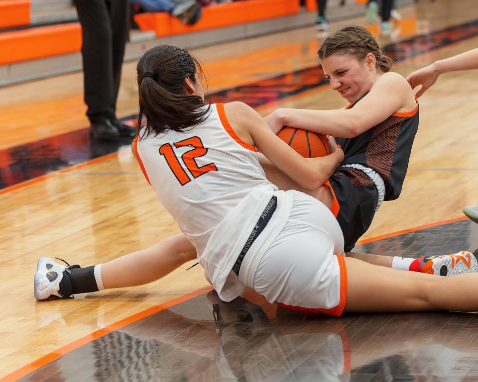 Brighton's Noelle Ebel and  Northville's Susy Heller (12) battle for a loose ball during the Bulldogs' 43-41 victory on Friday, Jan. 13, 2023.