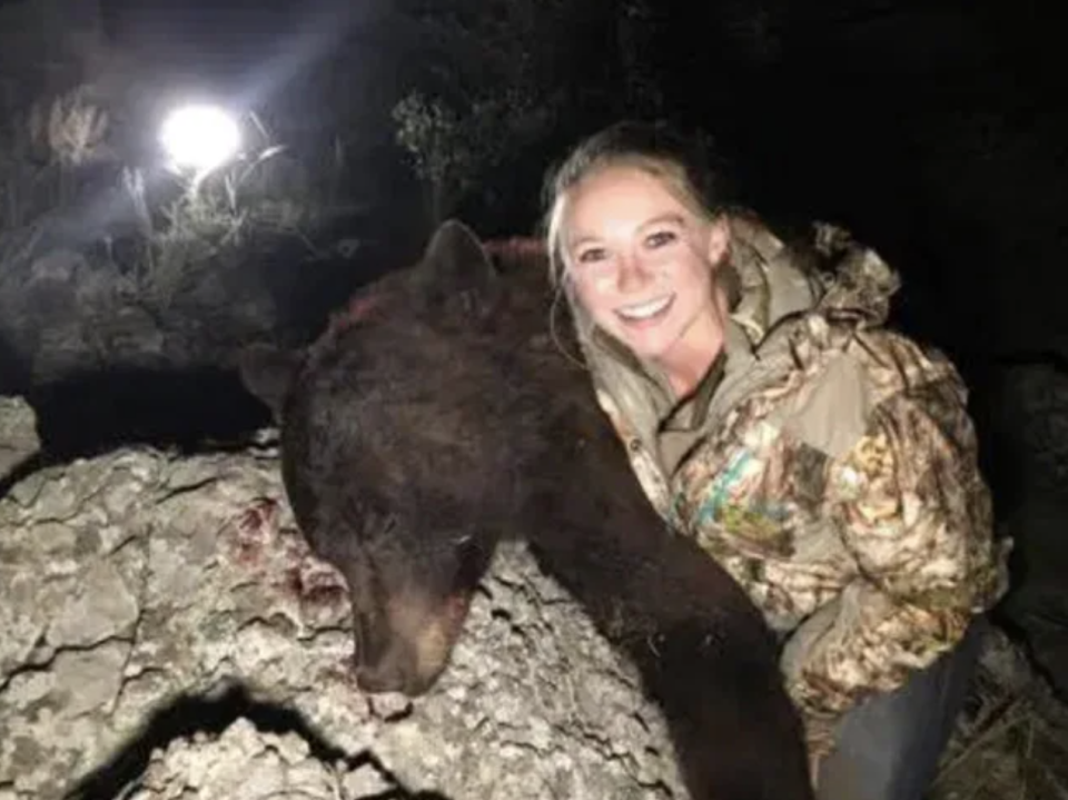 The 26-year-old posing with a dead brown bear.